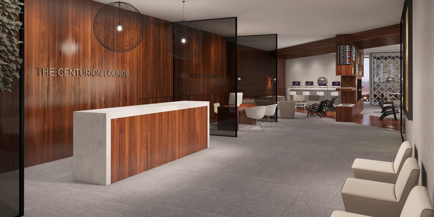 Reception area of the Centurion lounge by American Express features a fancy desk with a marble top and sides with dark stained wood as the center and wall behind.