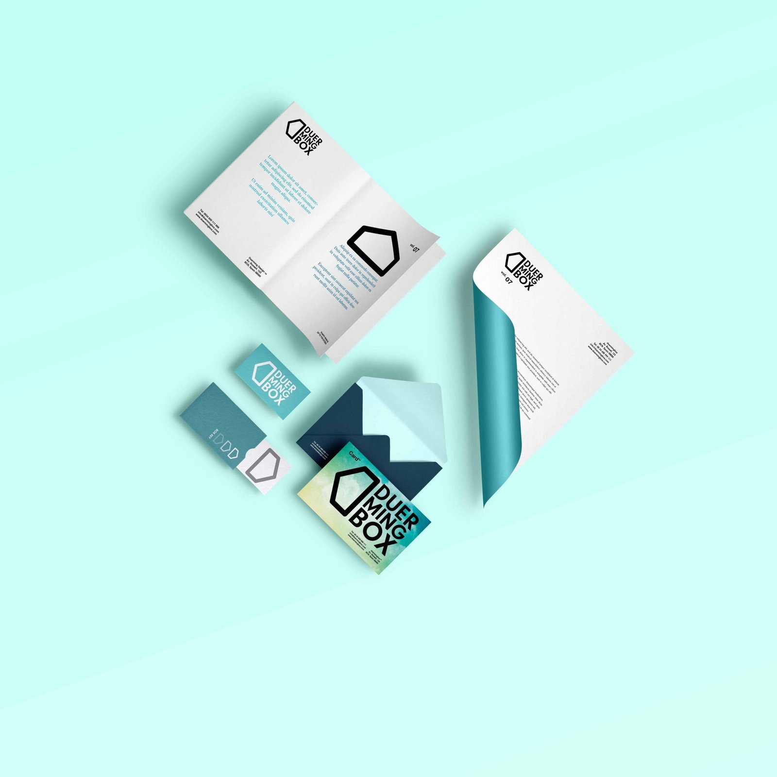 Duerming Box branding mockup with a brochure, letterhead, envelope and cards arranged on a turquoise background.