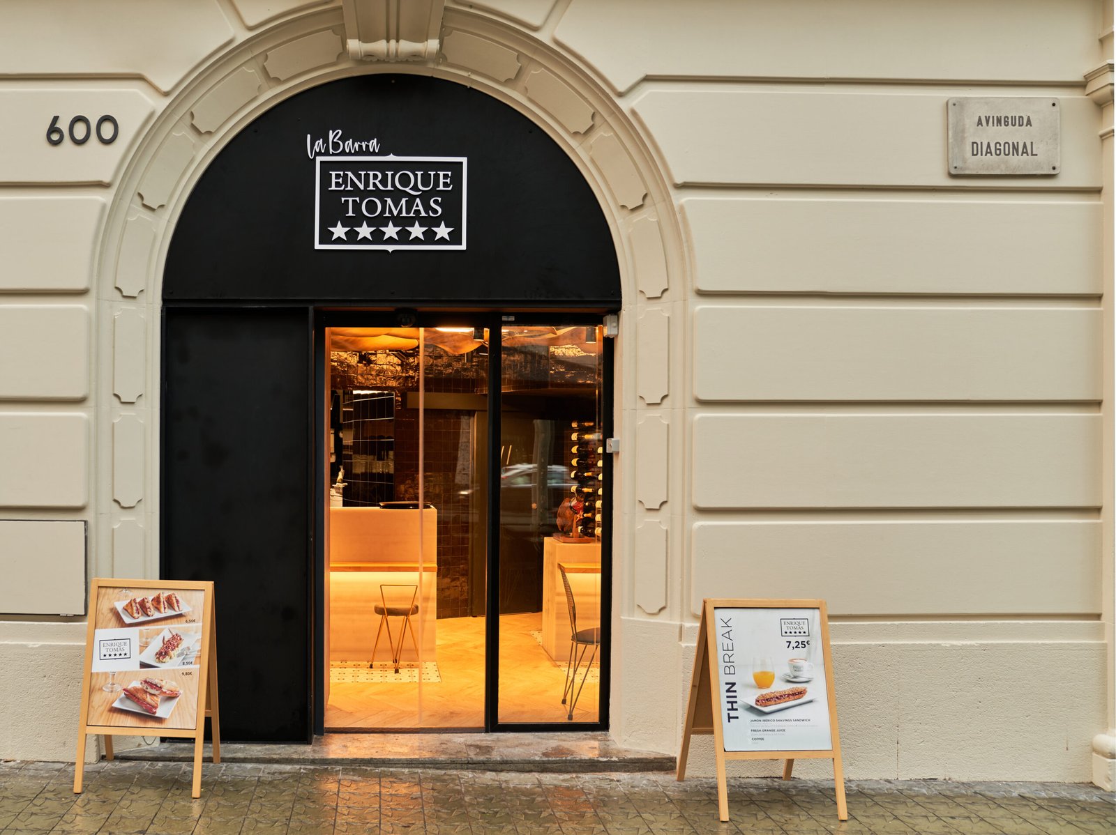Arched entrance to the Enrique Tomás Experience store on Avinguda Diagonal, Barcelona, with branded signage and menu boards outside.